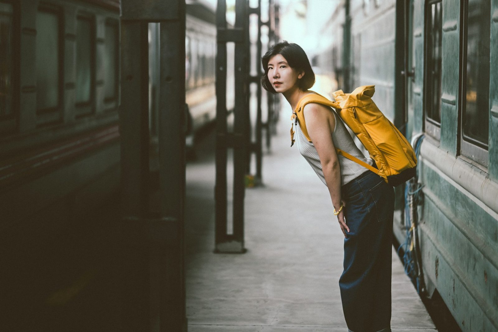 Viajante com mochila amarela em uma plataforma de trem